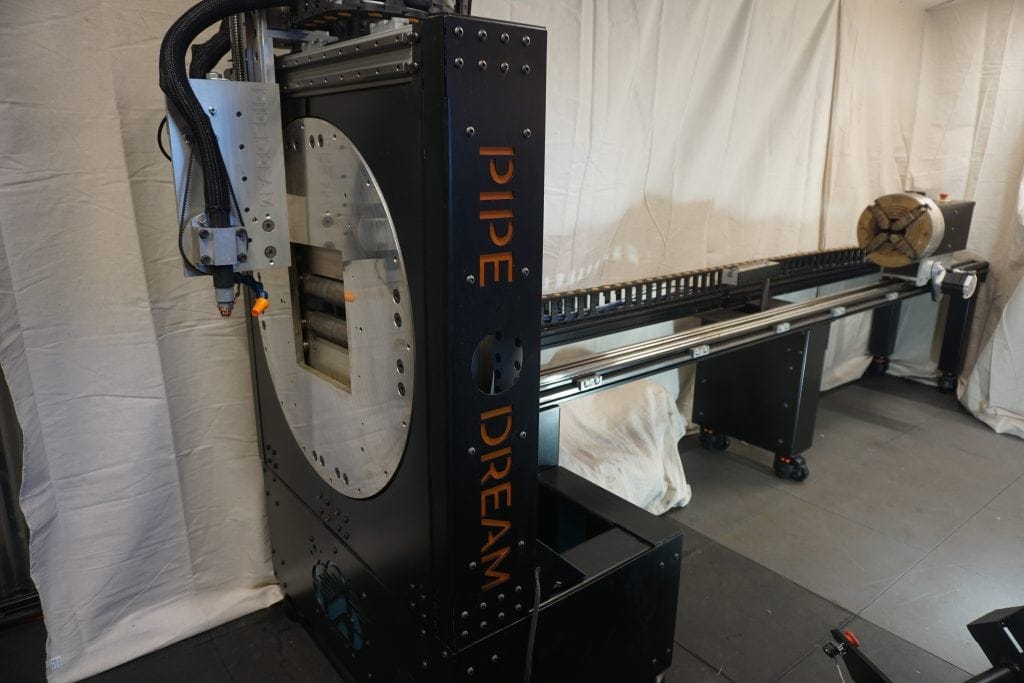 Full view of the Pipe Dream CNC PD-10 pipe cutting machine with automated rotary fixture and linear track system.