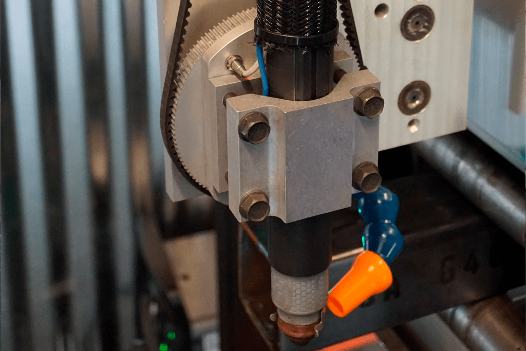 Close-up of the CNC plasma torch head on the Pipe Dream CNC pipe cutting machine showing cooling and precision engineering.